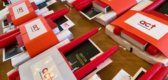 Ljus, informationsfolder, tändsticksask och servetter paketerade till små julgåvor.