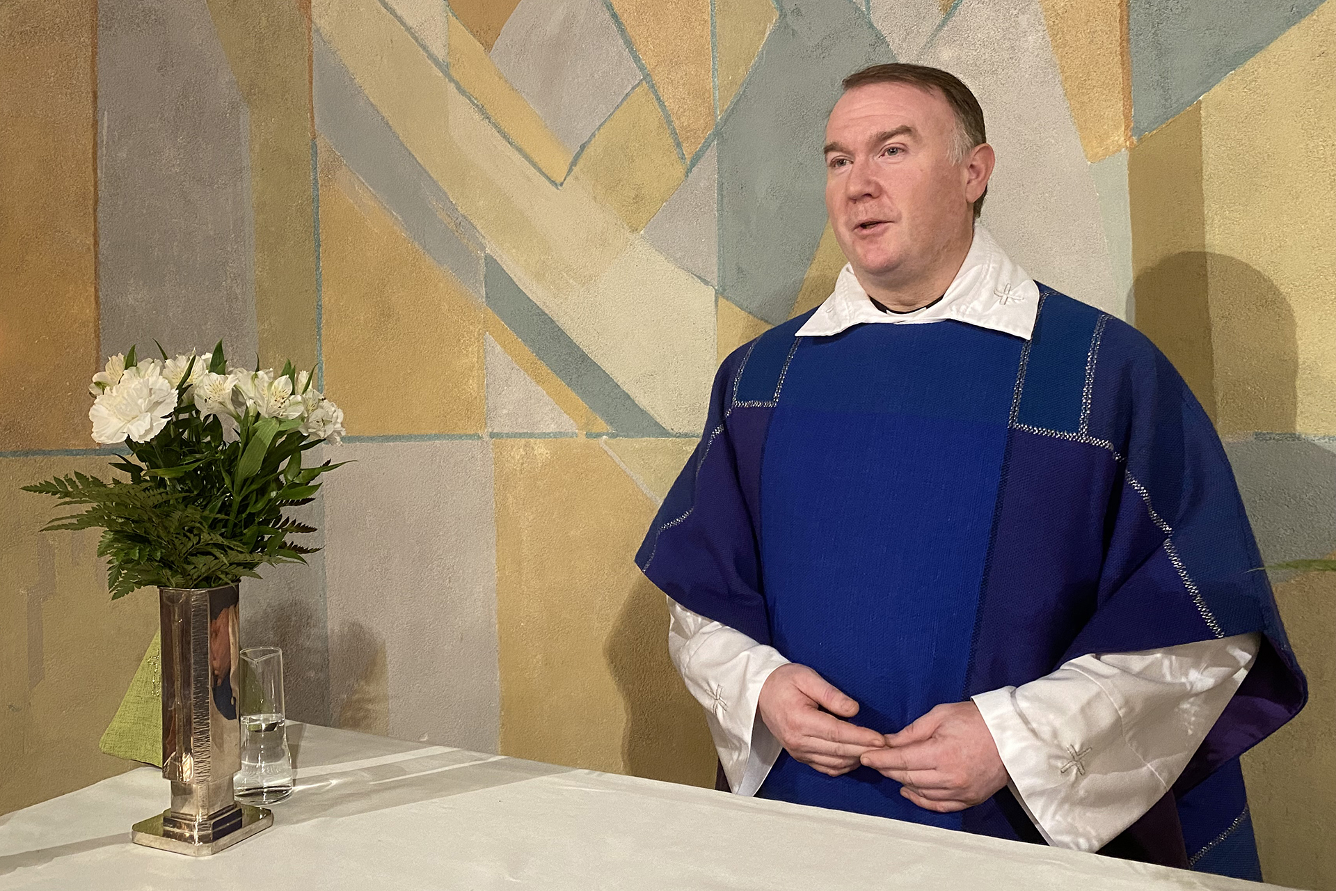 Kyrkoherde Hans Johansson står vid altaret och leder gudstjänst.