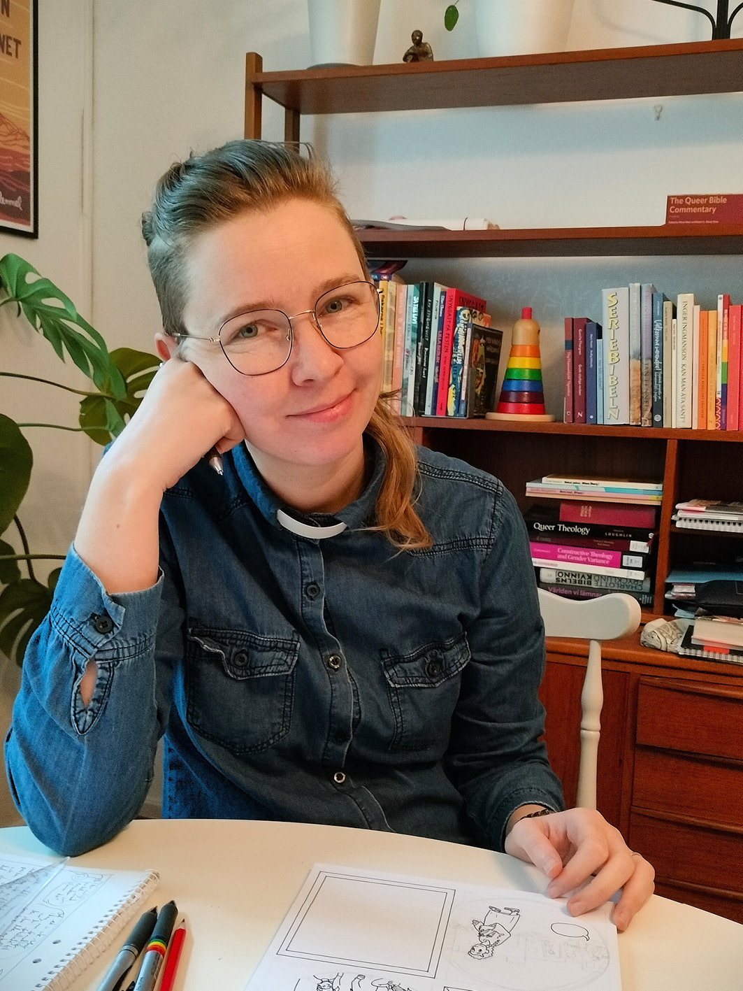Serietecknare framför bokhylla