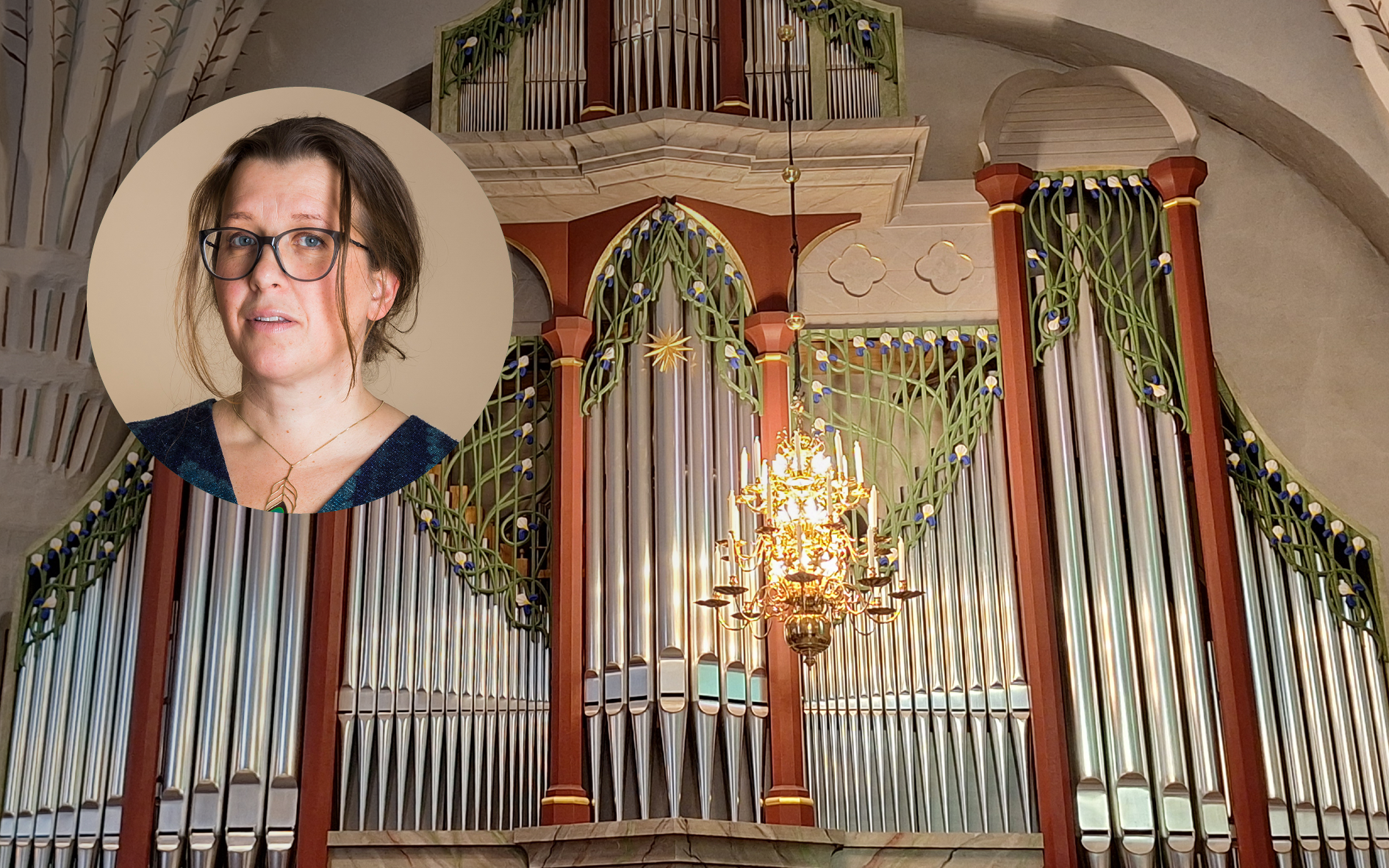 Anna Holm, organist i Stockholms stadshus, på bild inklippt framför fasaden på den stora orgeln i Backens kyrka. Orgelpiporna är silverfärgade och orgeln inramad i vinrött trä dekorerad med vita, gröna och blå blomrankor i trä.