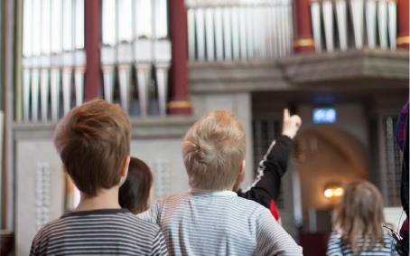 Barnen tittar upp mot orgel
