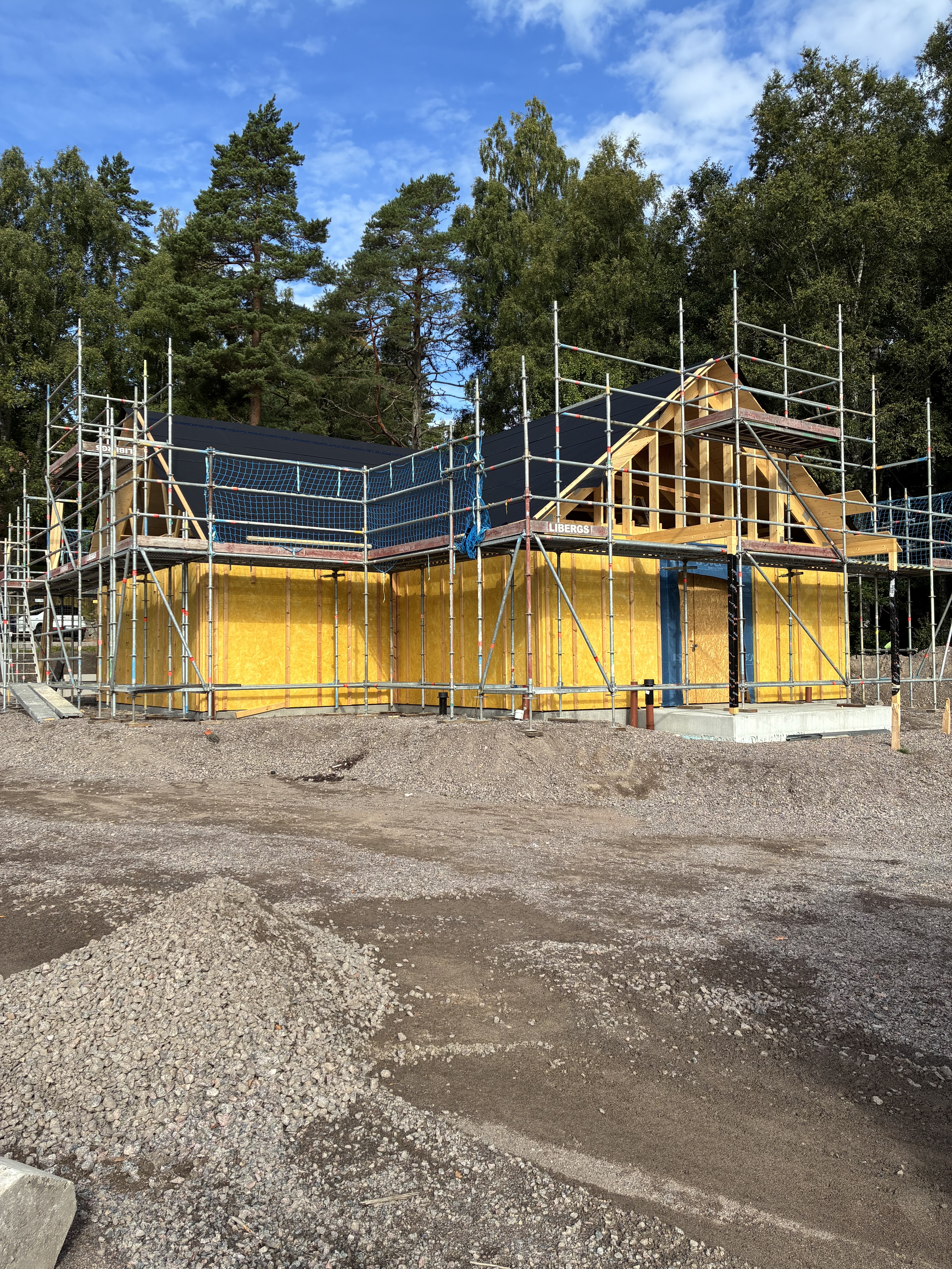 Ett hus under uppförande med byggställningar runt.