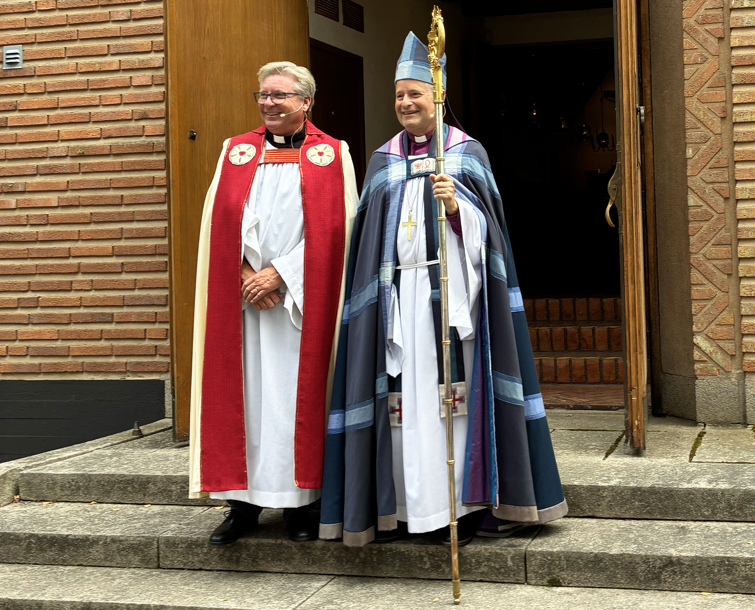 Präst och biskop på kyrktrappa.