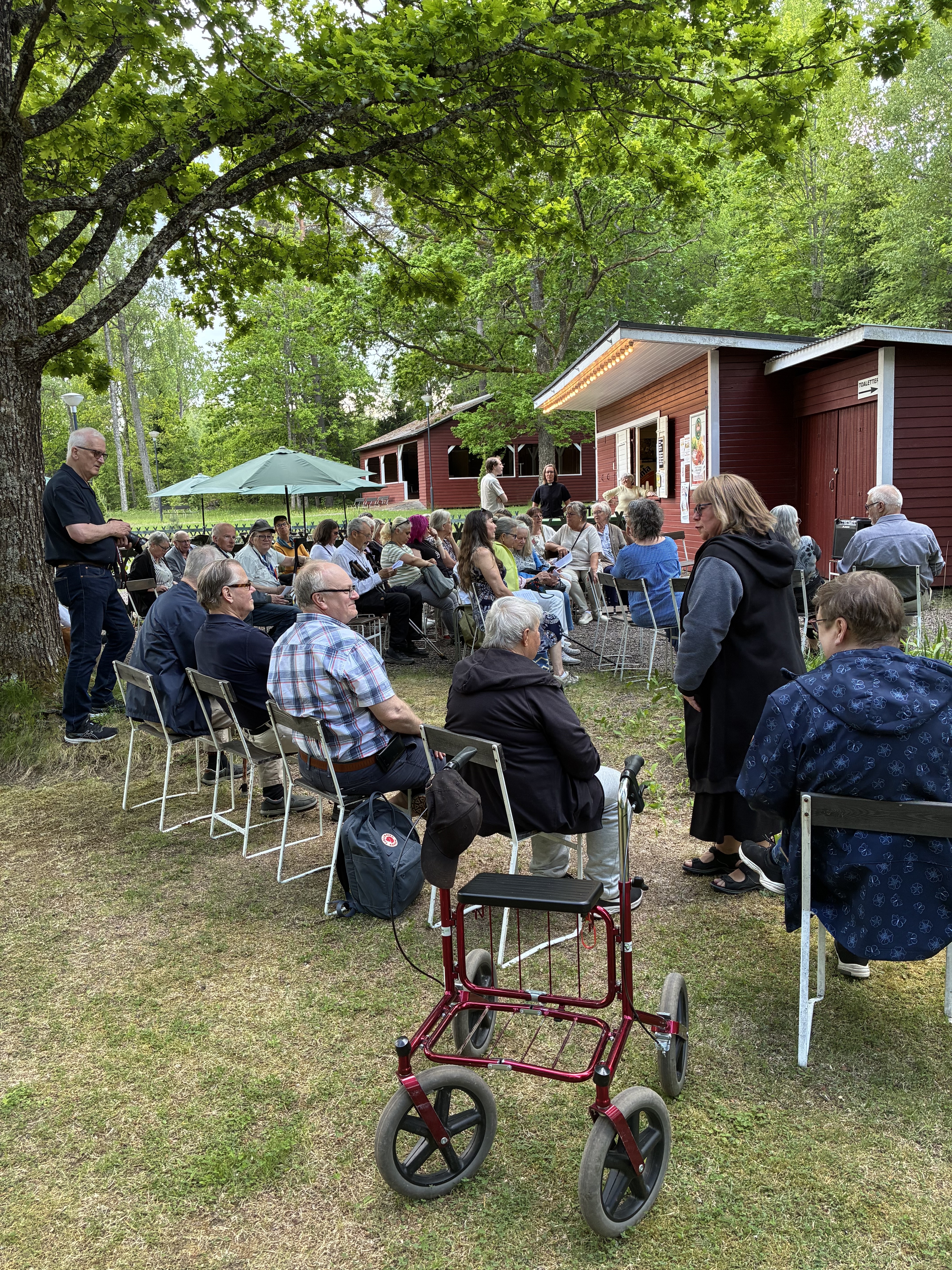 Många människor på stolar i publiken i folkets park.