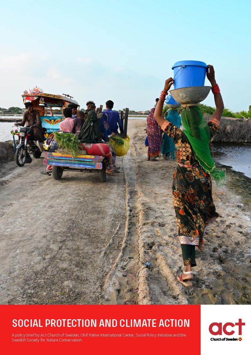 A man riding a motorbike, a bunch of people riding a cart and three women walking on a road. 