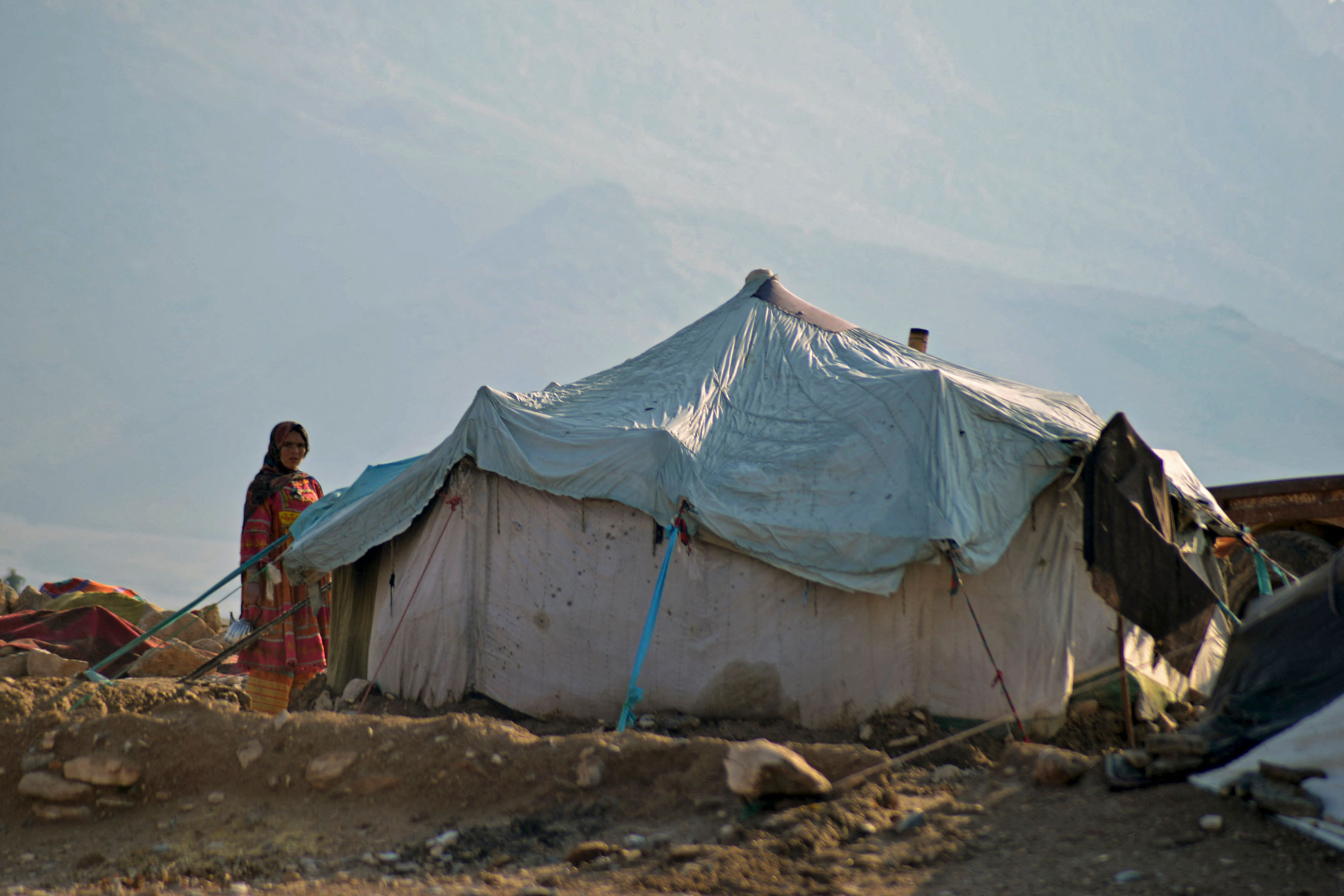 En afghansk kvinna står utanför sitt tält i Arghandab-distriktet i Kandahar