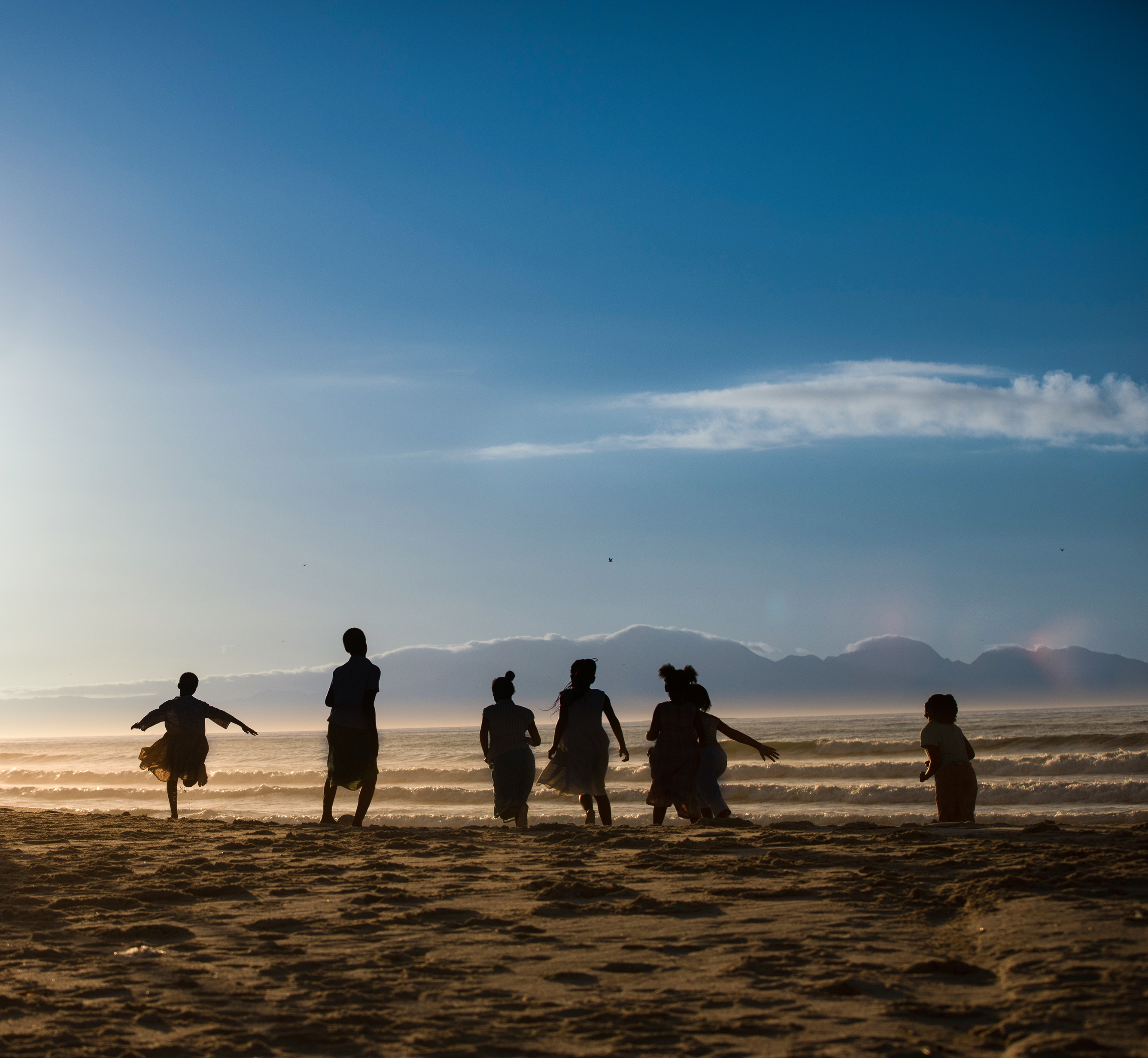 Barn och unga leker på en strand