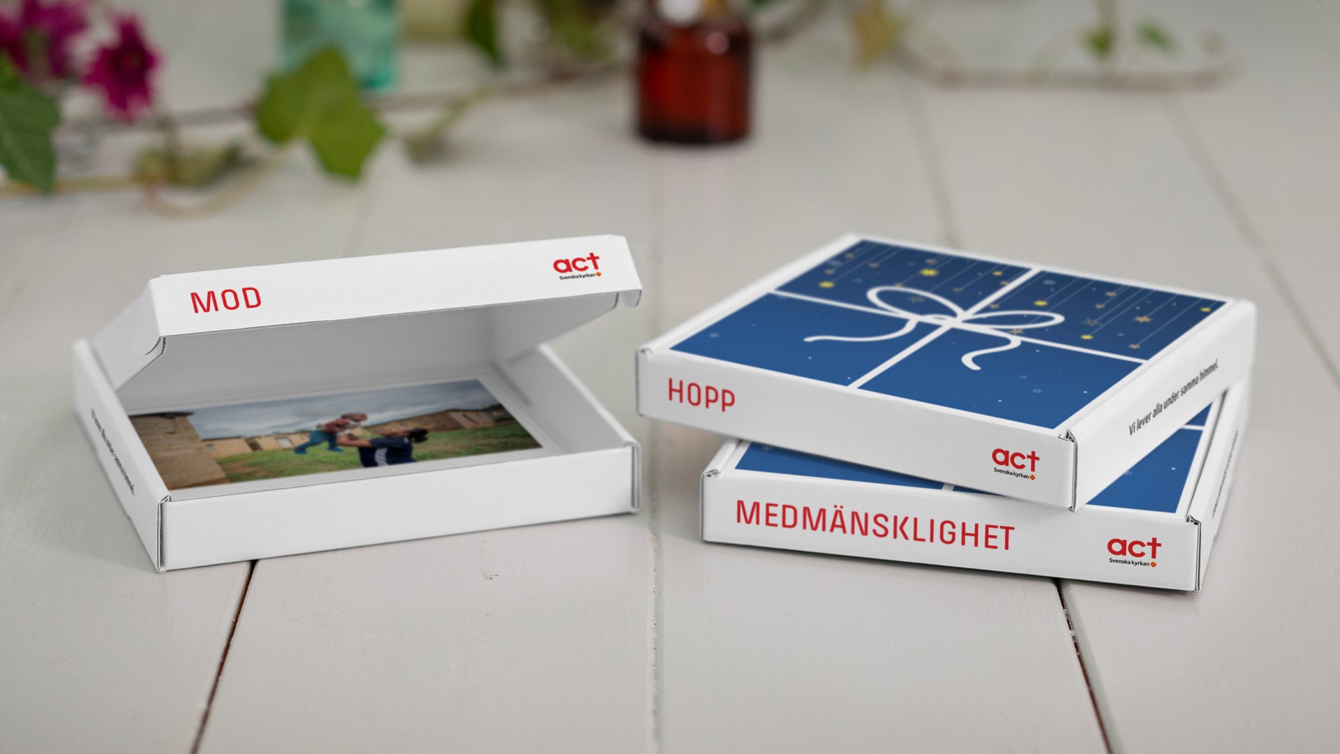 Tre presentaskar ligger på ett bord. På askarna står orden mod, hopp och medmänsklighet. En gåva som gör skillnad. 