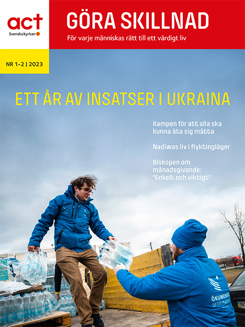 Framsidan till tidningen göra skillnad. En man står på en lastbilsflak och räcker ut vattenflaskor till en annan man. Tekt på bilden: Ett år av insatser i Ukraina. 