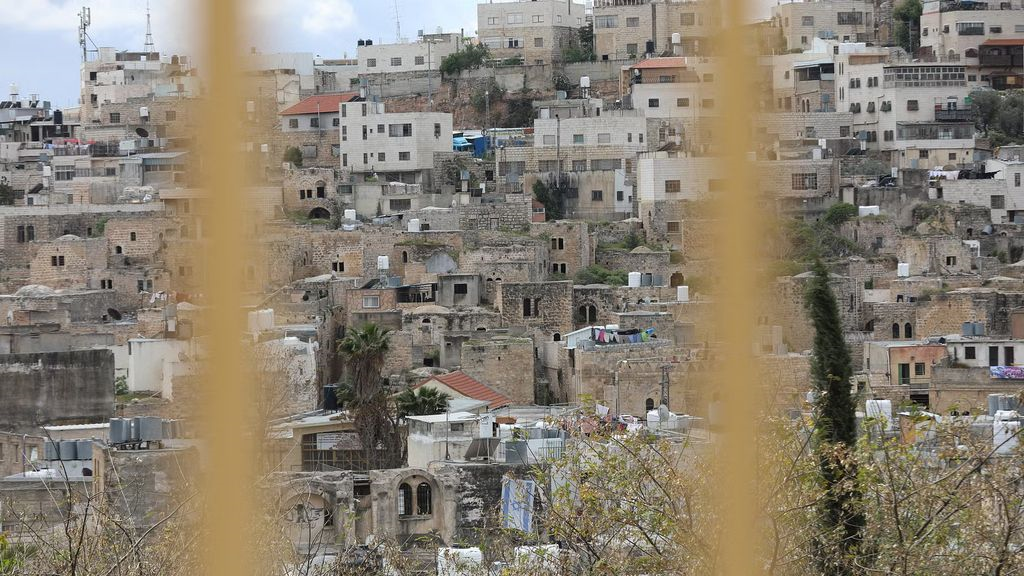 Hus i mellanöstern i bakgrunden med barriärgaller suddigt i förgrunden