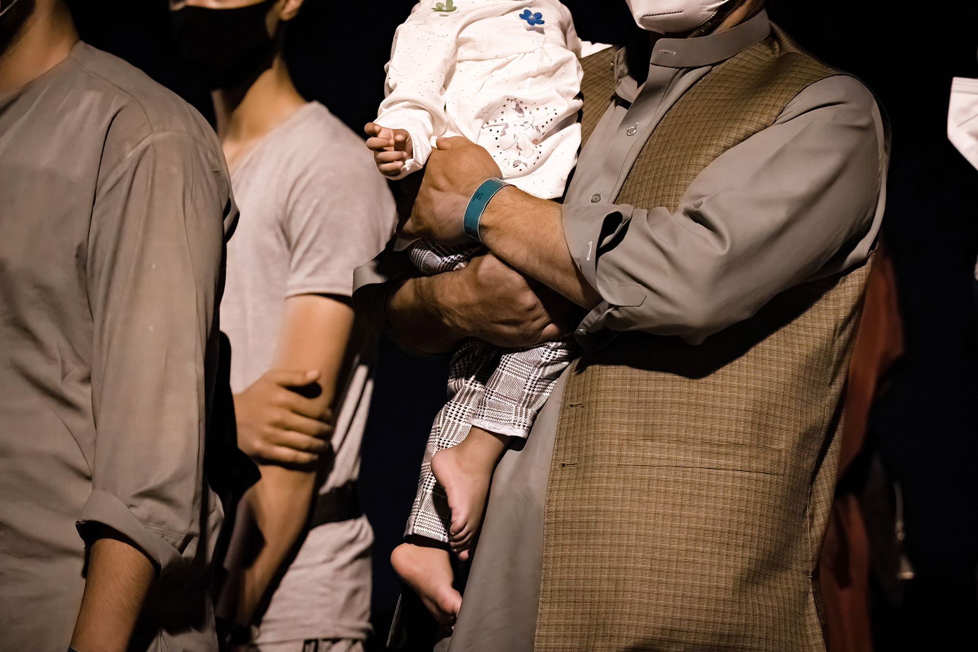 Tre män. En håller i ett barn.