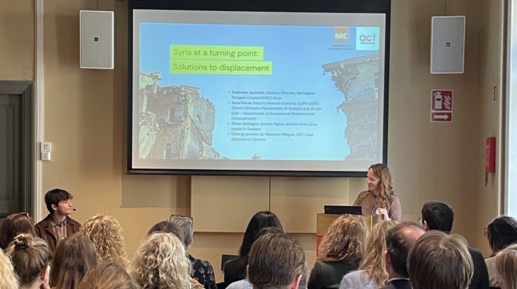 Talare och en presentation framför publik