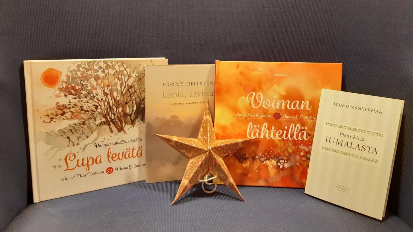 En bild på fyra böcker med finska titlar. I mitten av dem en julstjärna.