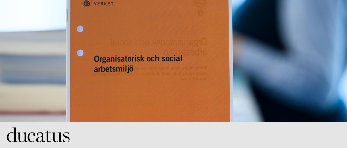 Enorange folder från arbetsmiljöverket står på en bänk. 