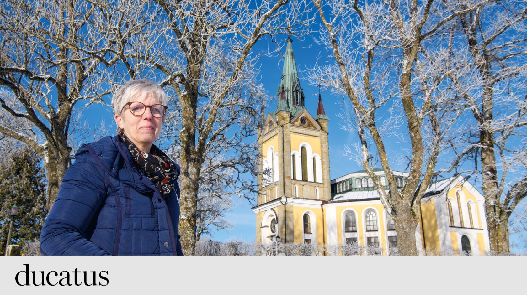 kvinna i täckkappa framför en stor kyrka. 