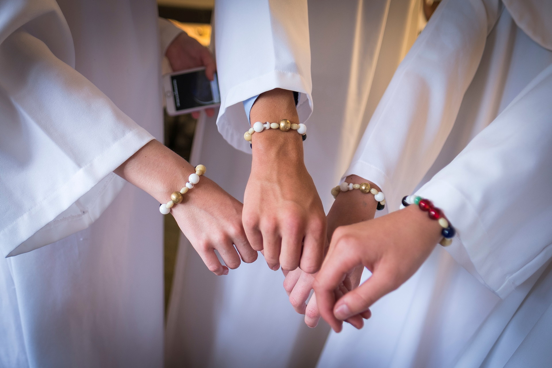 Händer med armbandet frälsarkransen.