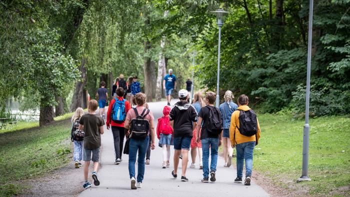 Grupp med barn som går i en park.