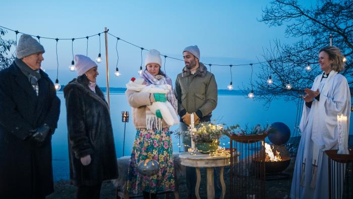 Dopfamilj och prästen vid utomhus