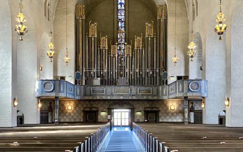 Inuti Högalidskyrkan, bänkar, lampor, valv och den stora orgeln. 