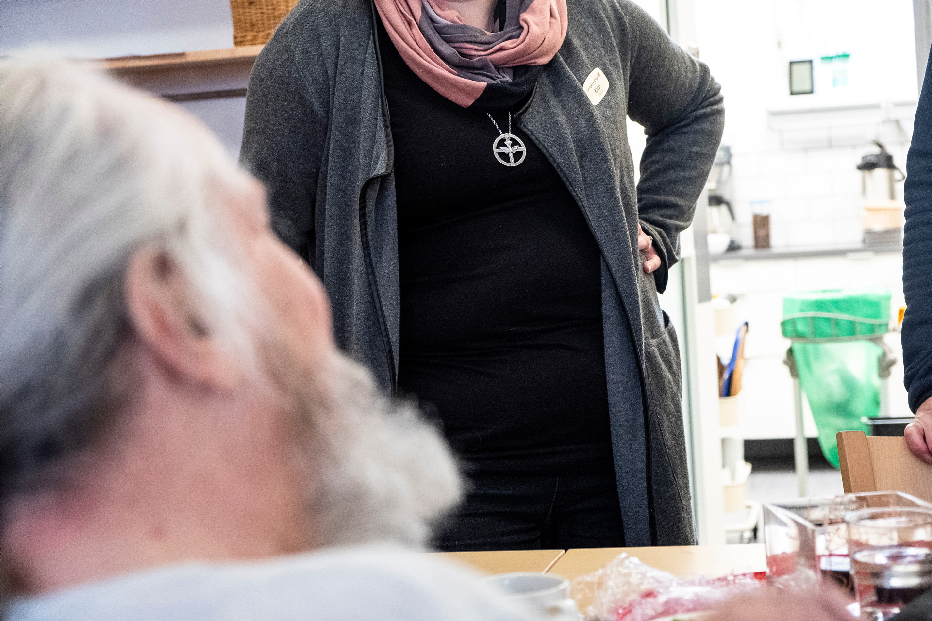 En man som skrattar och person med diakonmärket