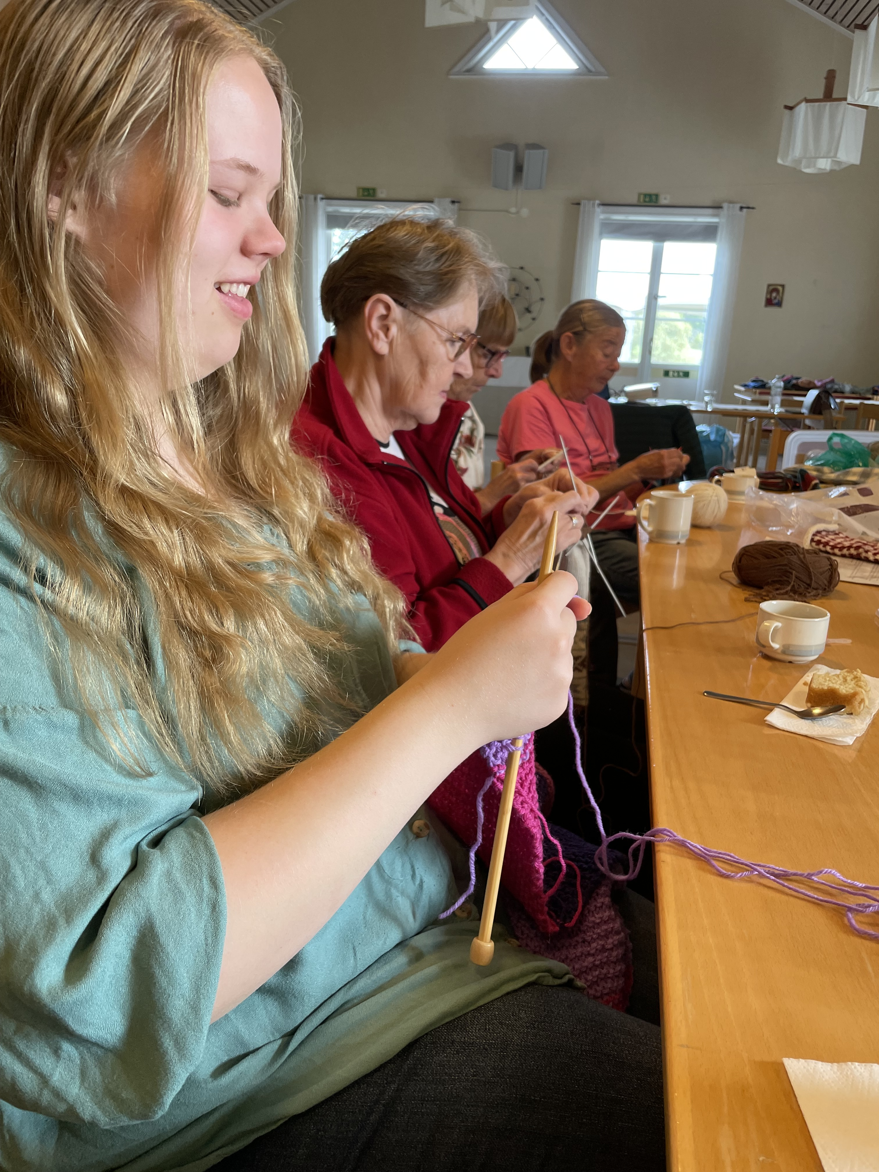 Personer sitter vid ett bord och stickar