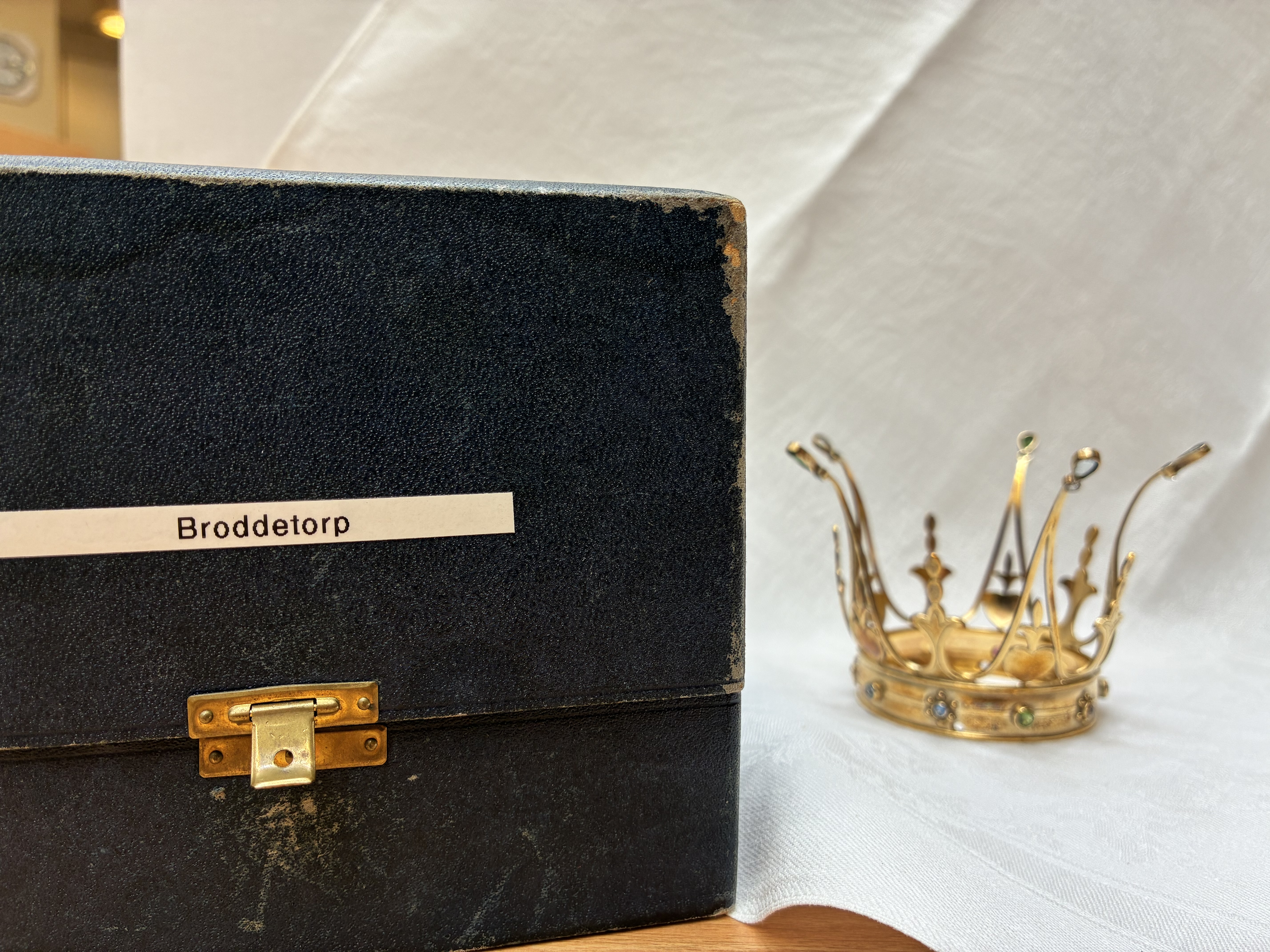 En krona i metall bredvid lådan den förvaras i