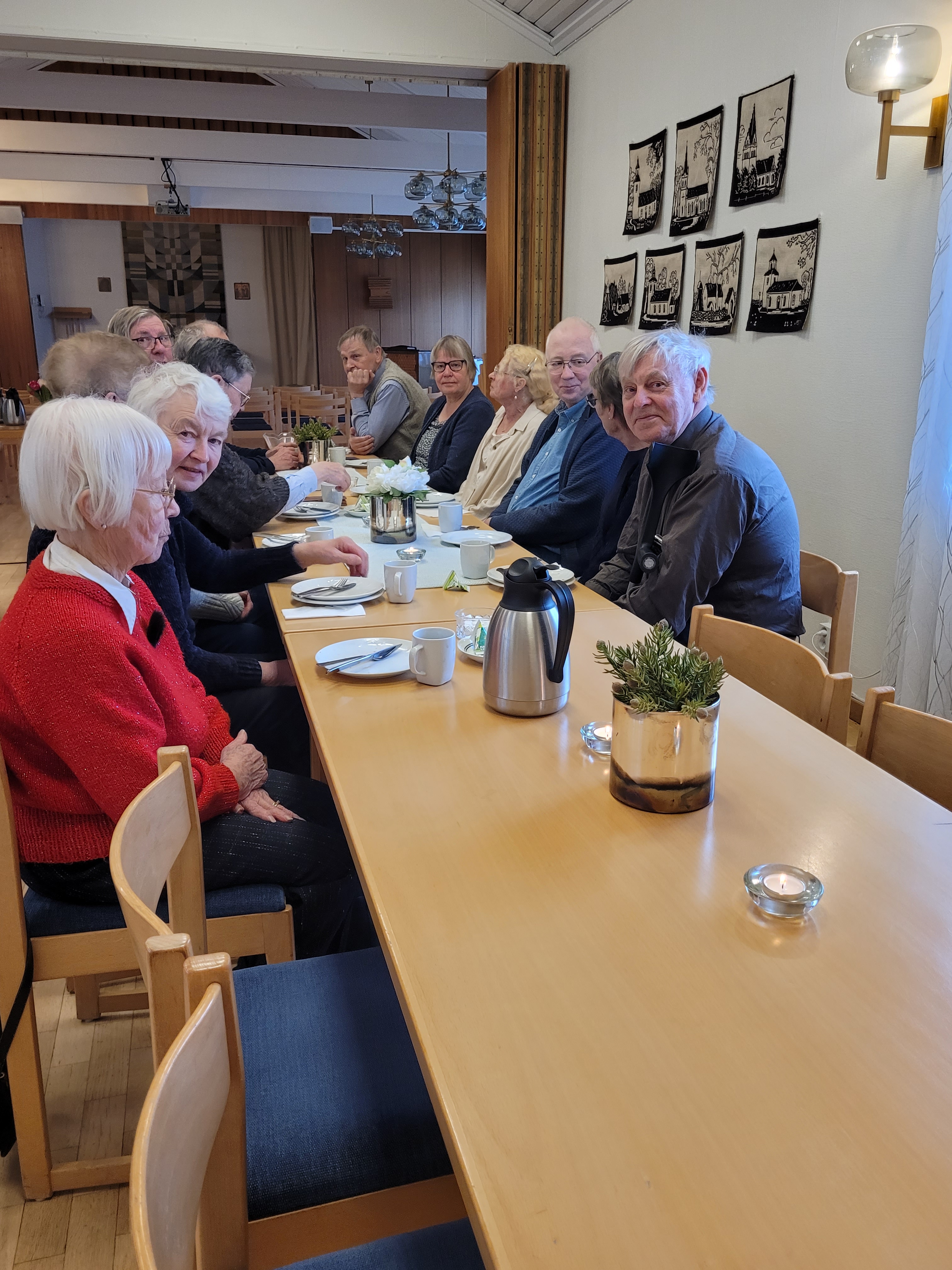 Fler män och kvinnor fikar vid ett bord
