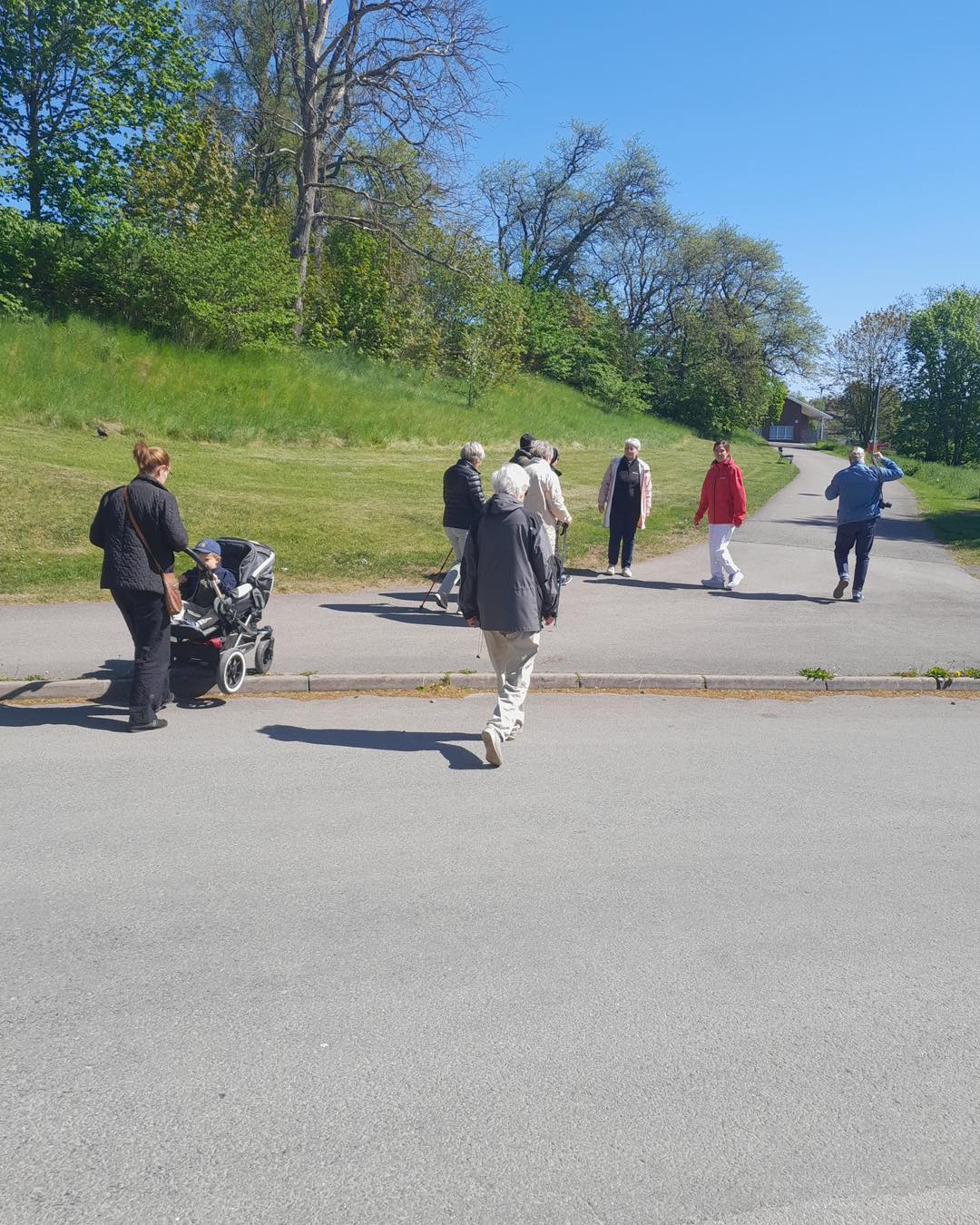 Människor i olika åldrar promenerar på en gångbana i asfalt