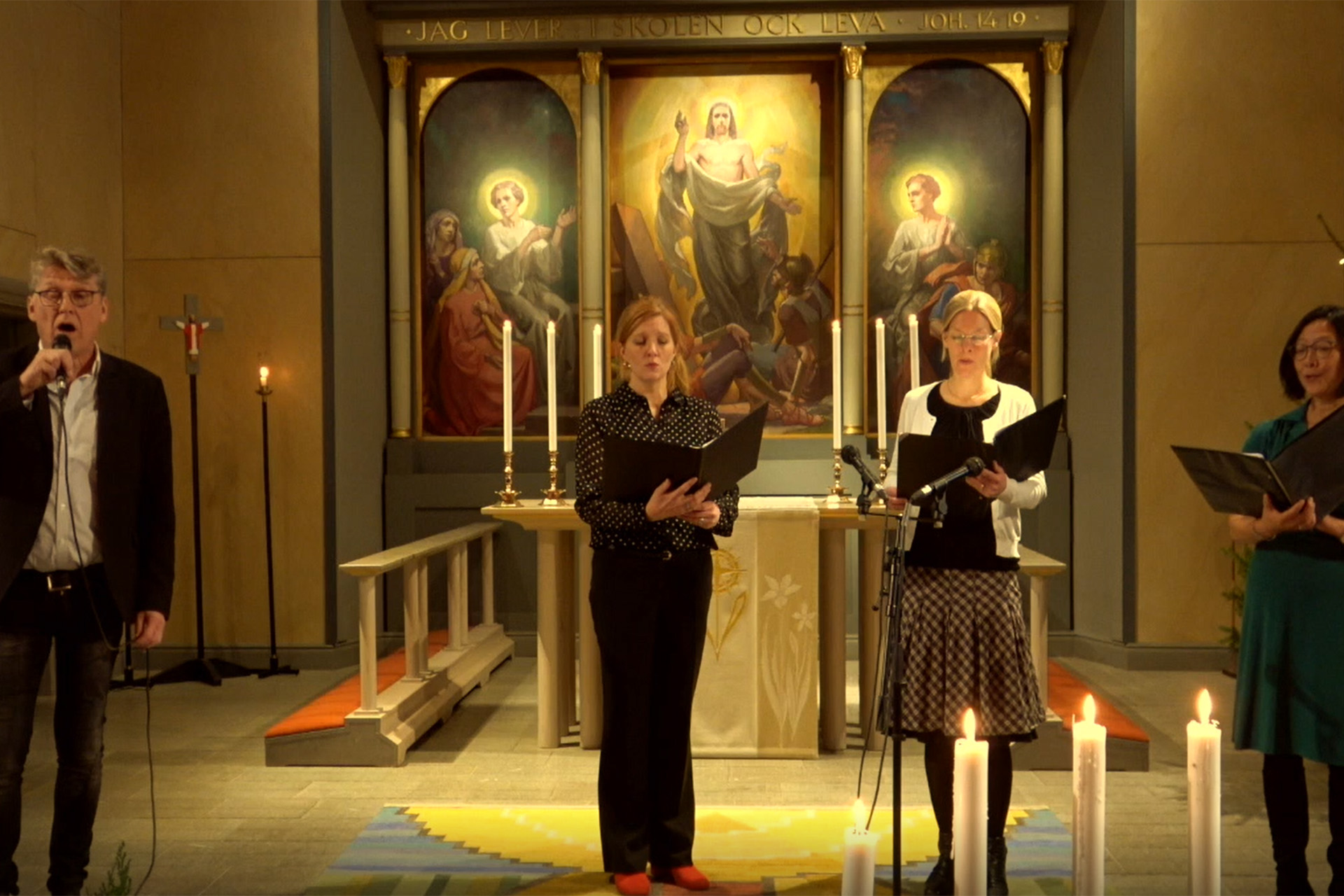Fyra körsångare sjunger framme i koret i Huskvarna kyrka