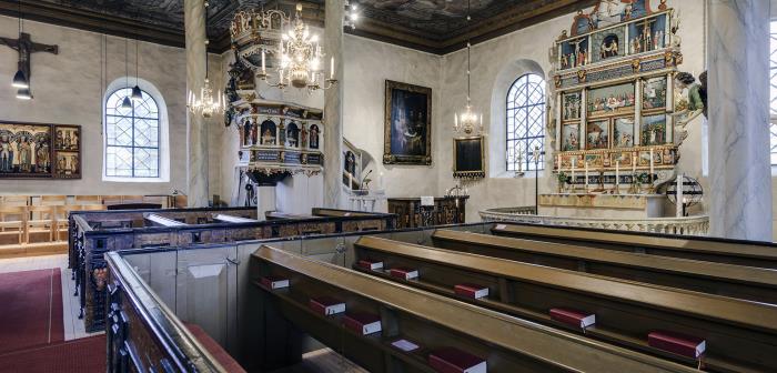 Interiör från Hakarps kyrka. I bänkarna ligger röda psalmböcker