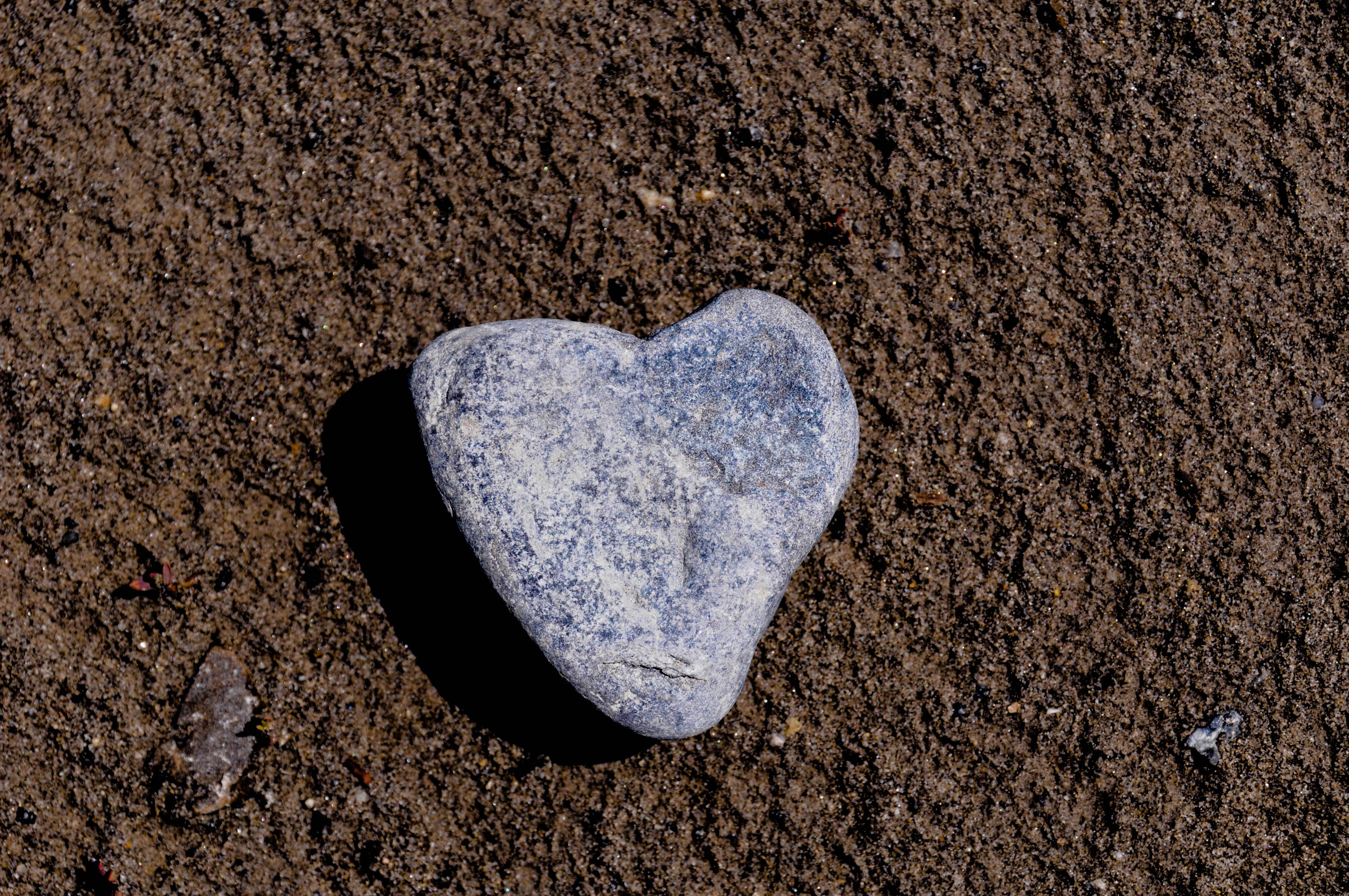 En hjärtformad grå sten ligger på marken