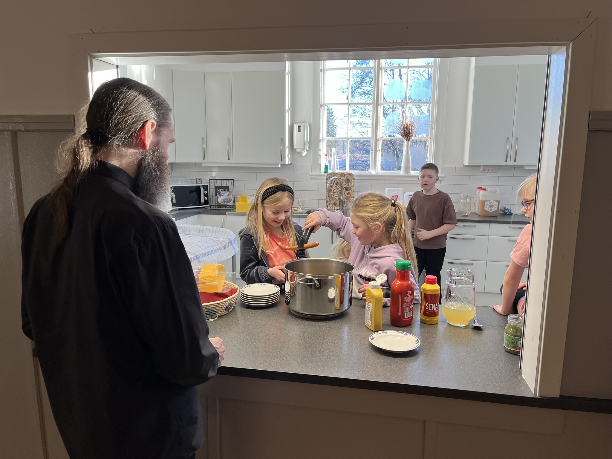 Barn serverar korv i Lyrestads församlingshem