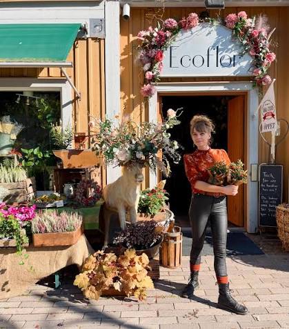 kvinna står utanför trädgårdsbutik
