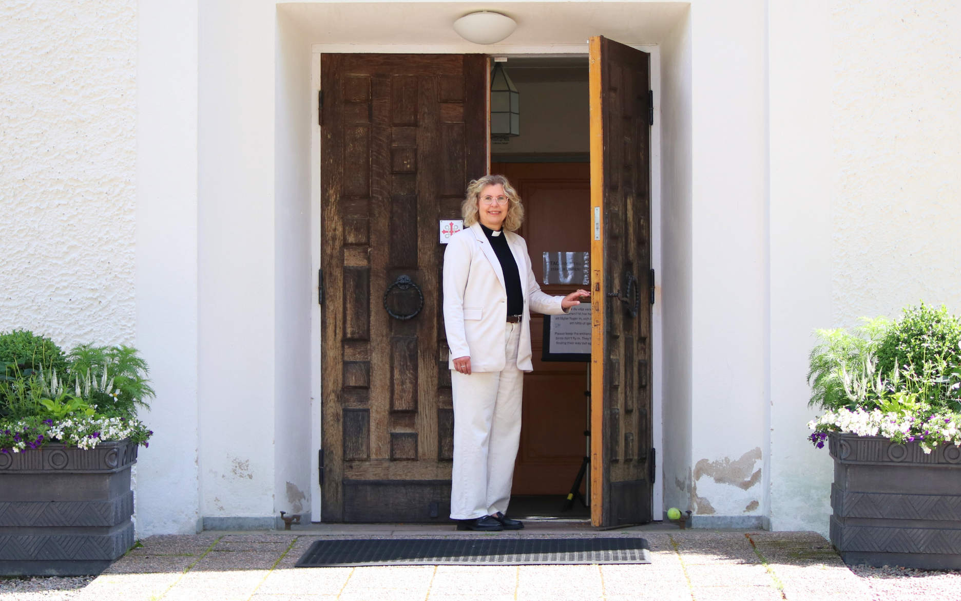 Annette Börjesson, ny kyrkoherde, står i dörröppningen till Västra Tunhems kyrka