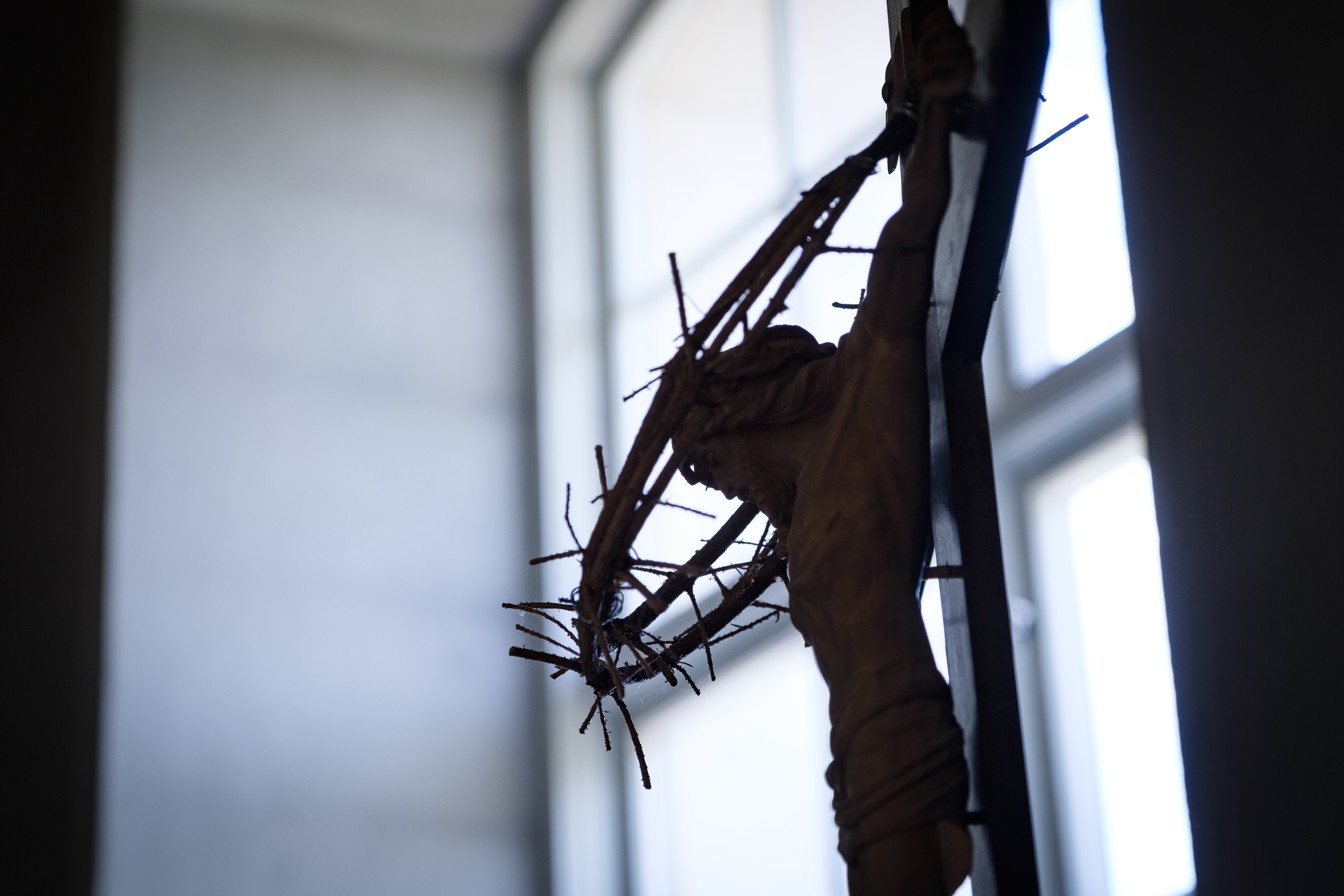 Krucifix framför ett kyrkfönster där Jesus hänger på korset. 