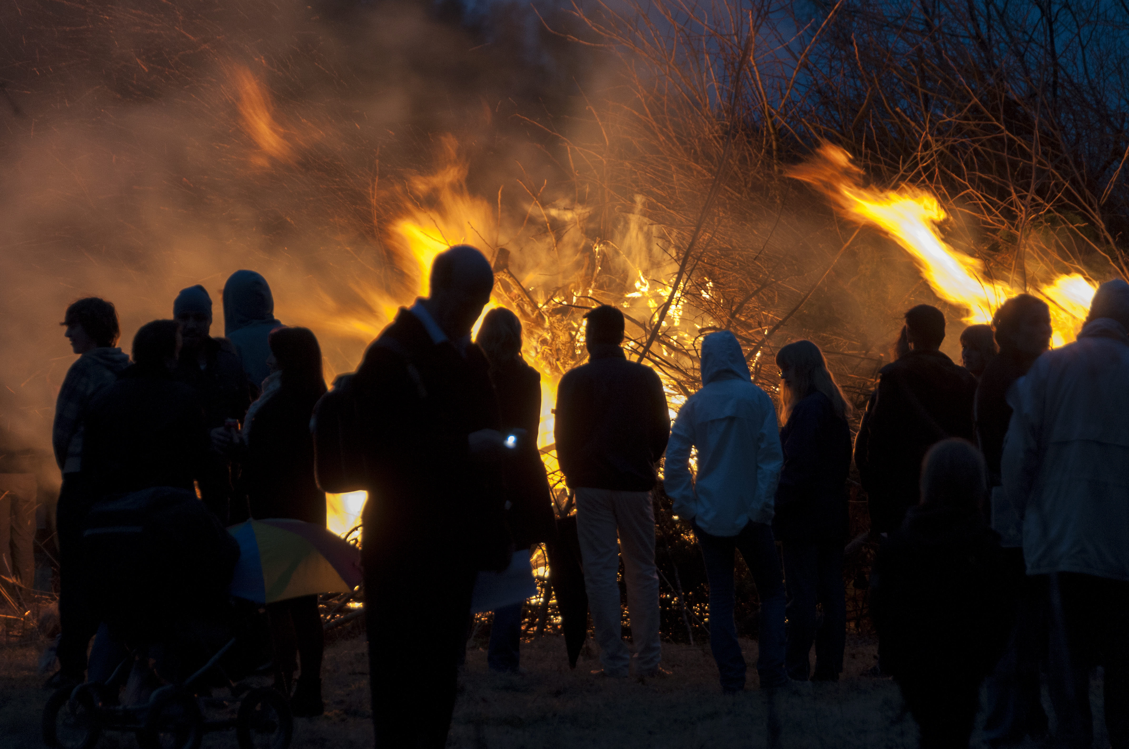 Människor samlade framför en majbrasa på Valborgsmässoafton. 