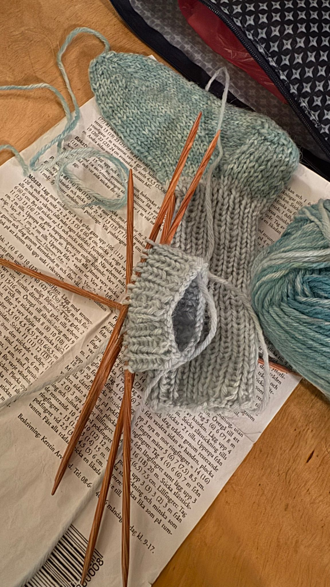 En socka som är påbörjad med stickor och garn