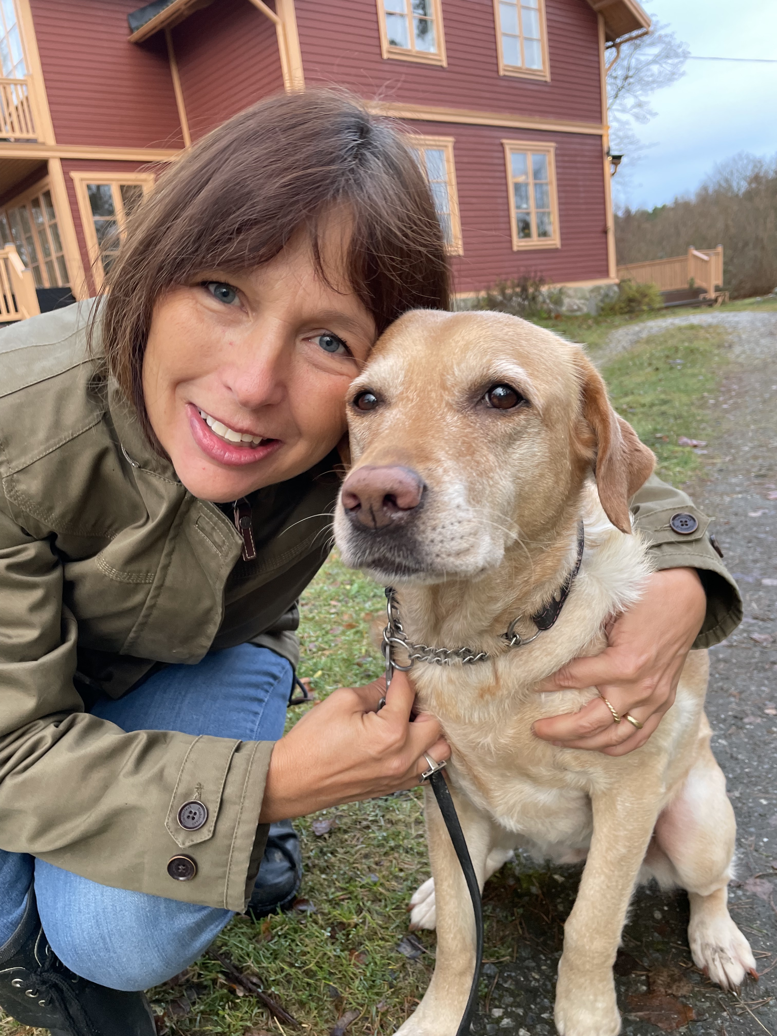 Kvinna kramar en hund.