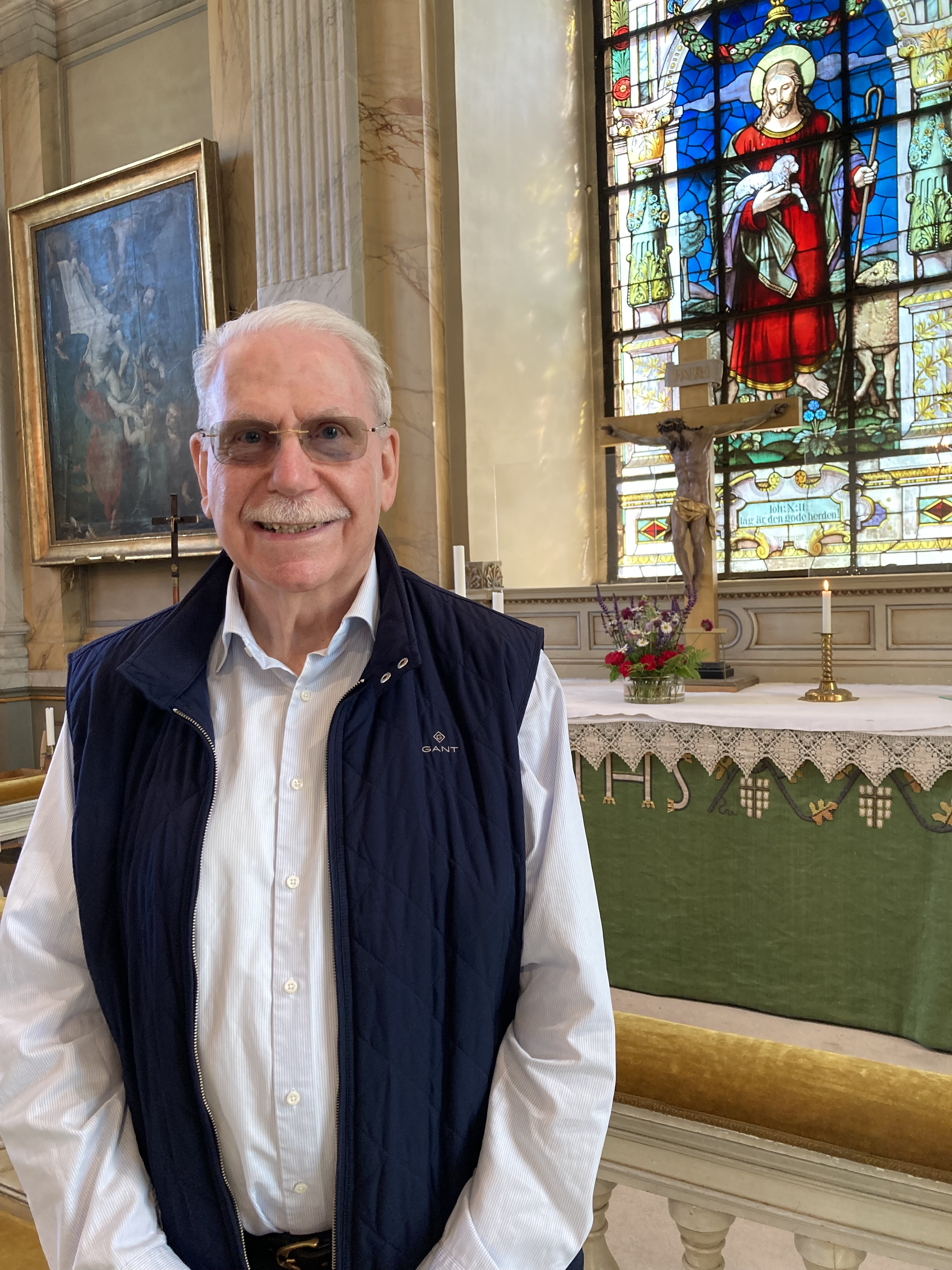 Man står och ler framför altartavlan i Vaxholms kyrka.