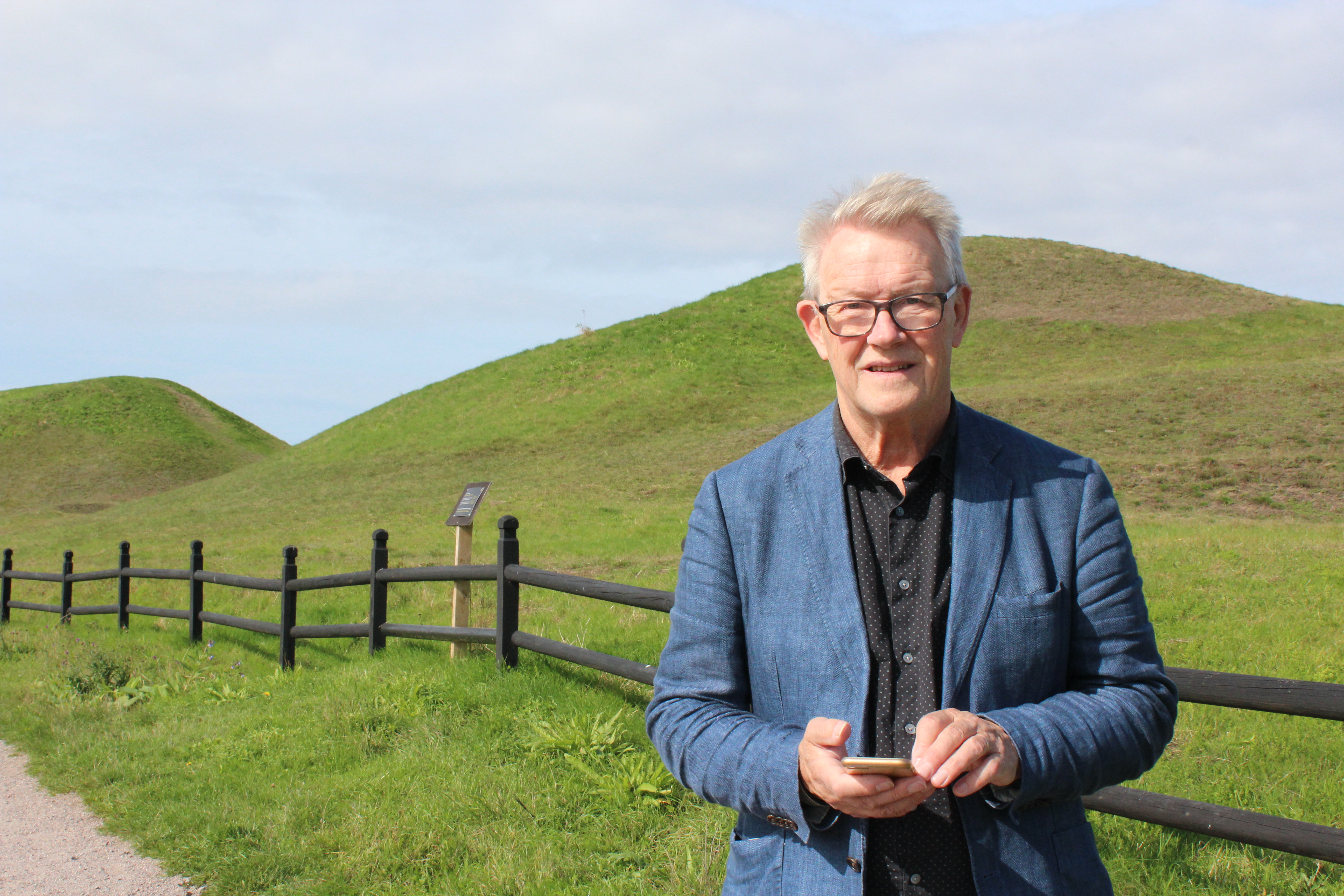 Prästen Lars Björklund ute framför gröna kullar.