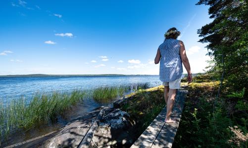 Kvinna går på stenar vid en sjö