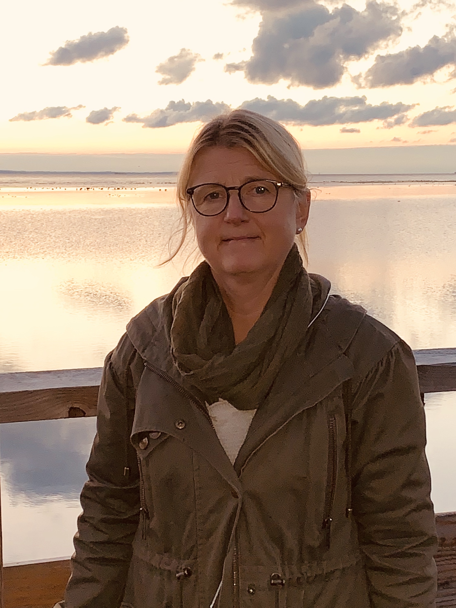 Bild på kvinna vid solnedgång vid vatten