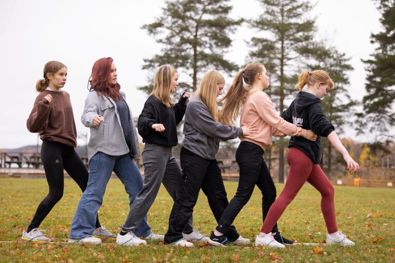 En grupp konfirmander över samarbete genom att ta sig fram på ett par flerpersonersskidor.