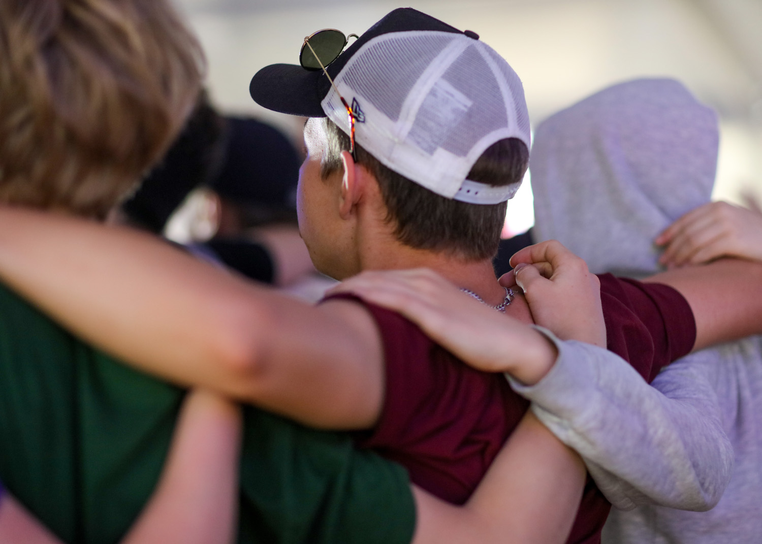 Tre ungdomar står med armarna om varandras axlar. 