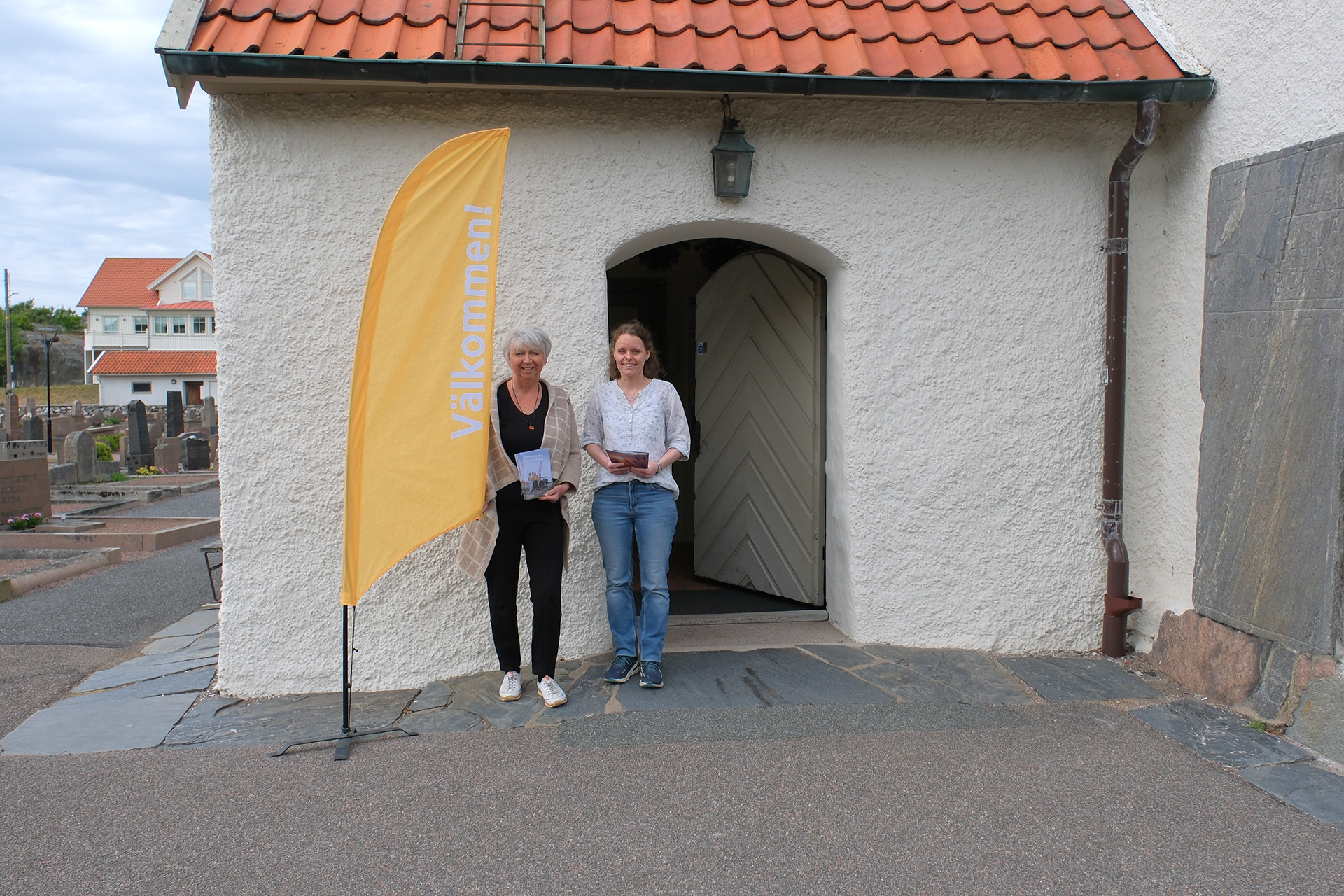 Volontärer välkomnar besökare utanför Öckerö gamla kyrka