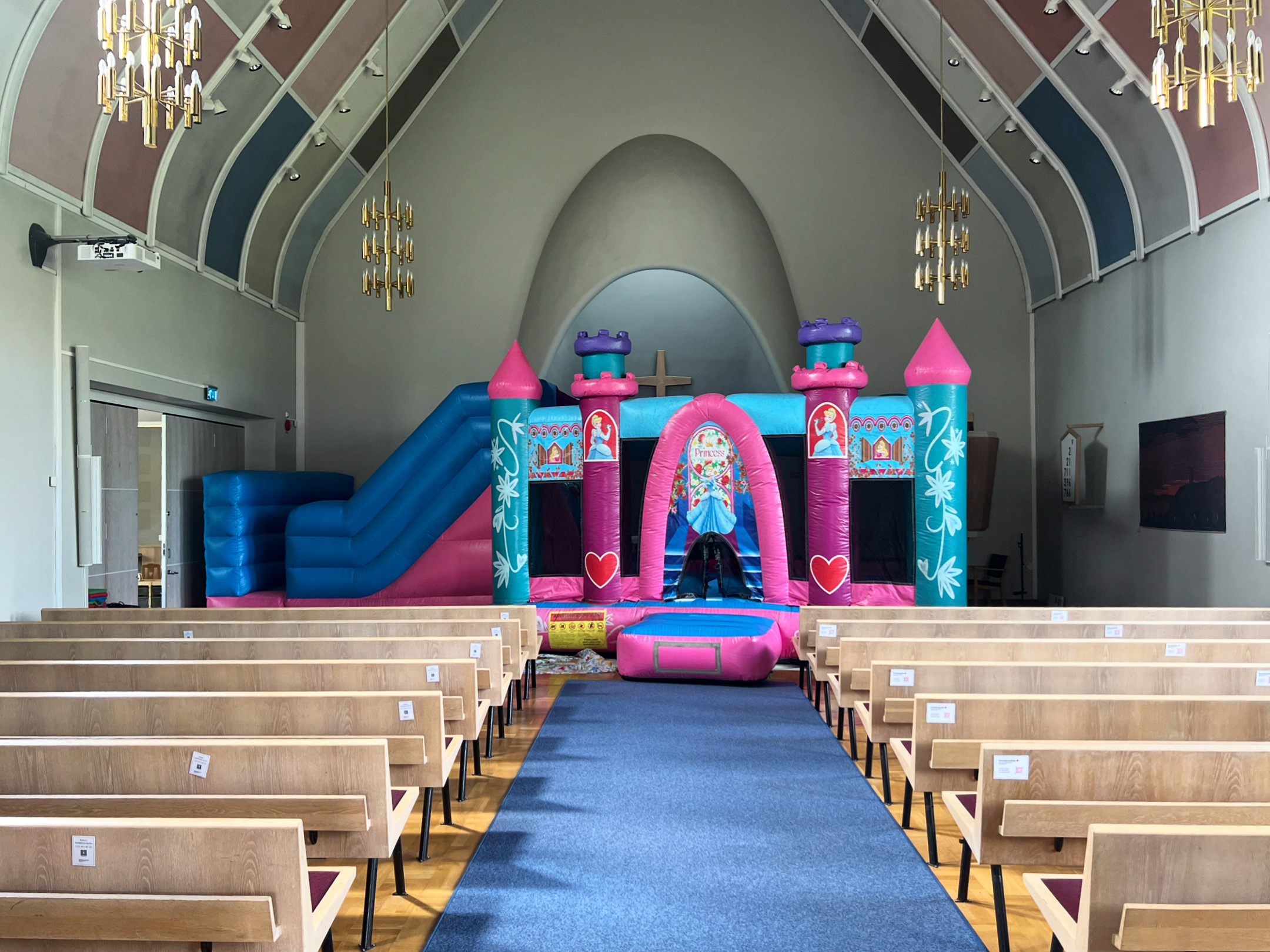 en rosa och ljusblå hoppborg framme i koret i Sandareds kyrka