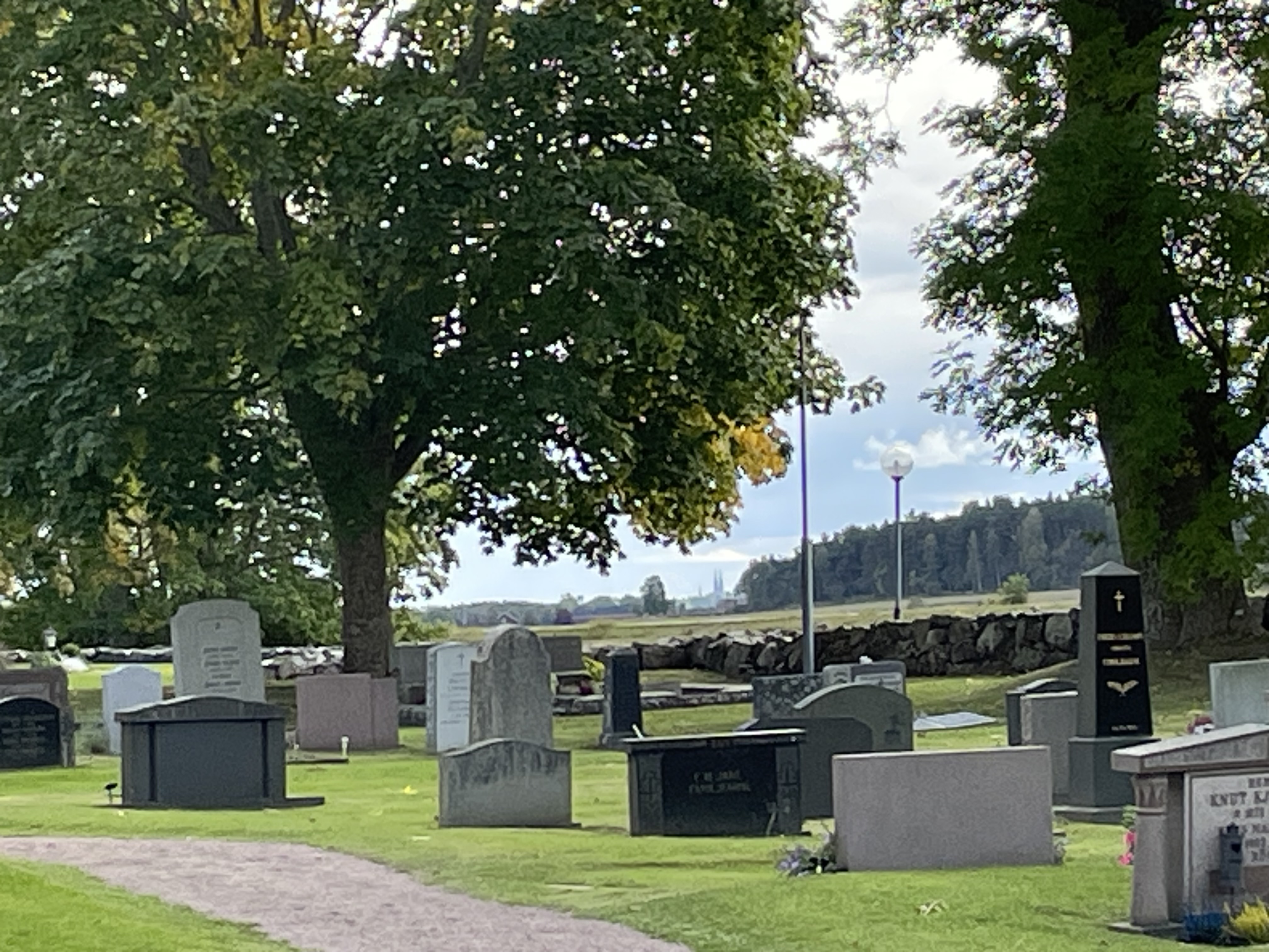 Kyrkogård äldre gravkvarter med utsikt mot Uppsala sensommar