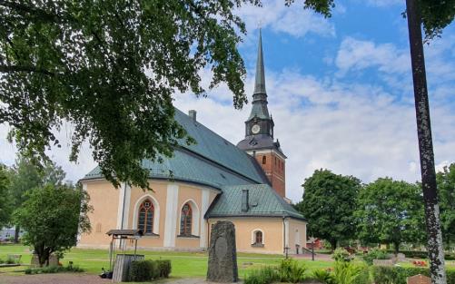 sommarvy mora kyrka ljusgul kyrka grönt koppartak tegelrött torn 