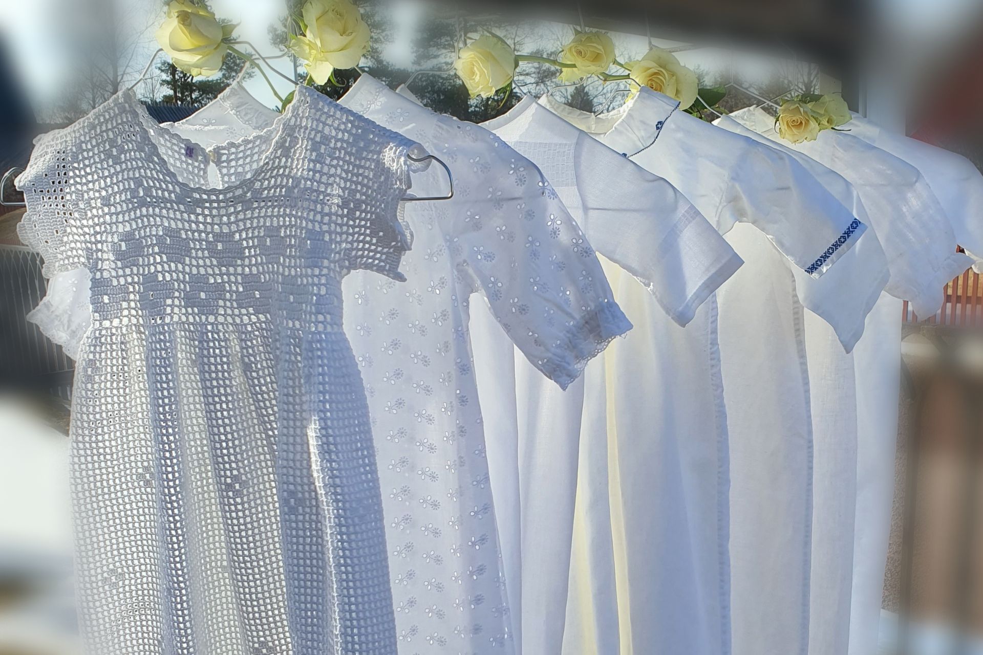 Sju olika dopklänningar hänger på galgar