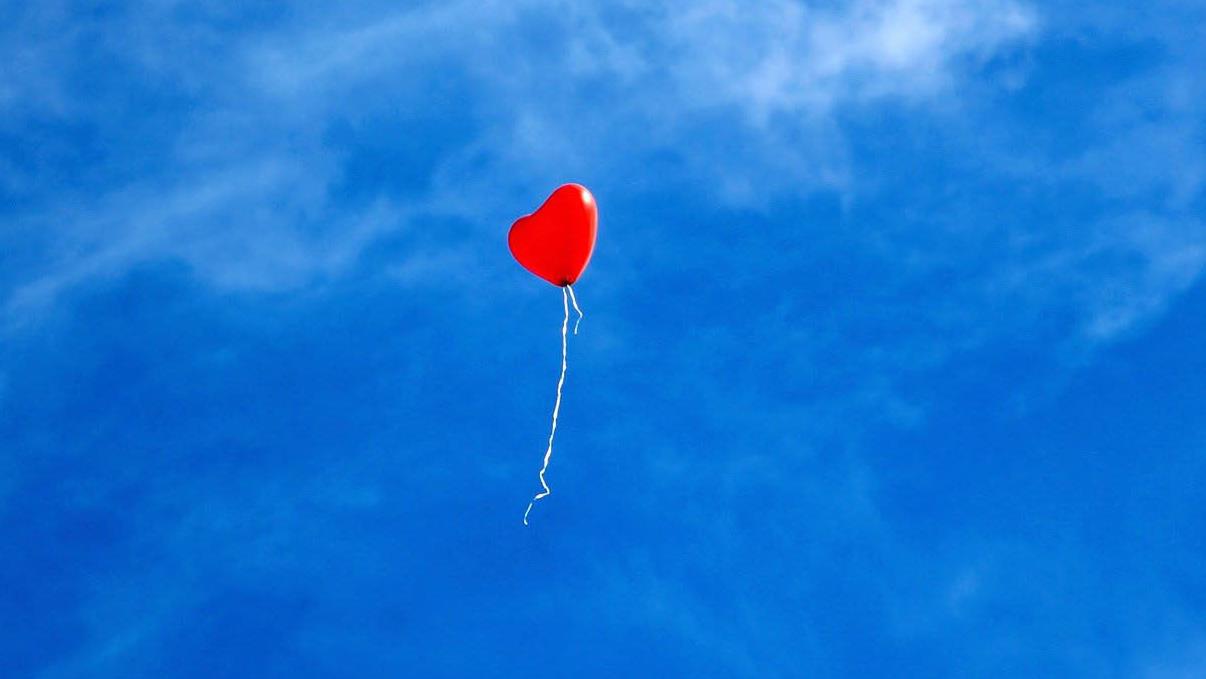 Bilden visar en hjärtballong mot blå himmel